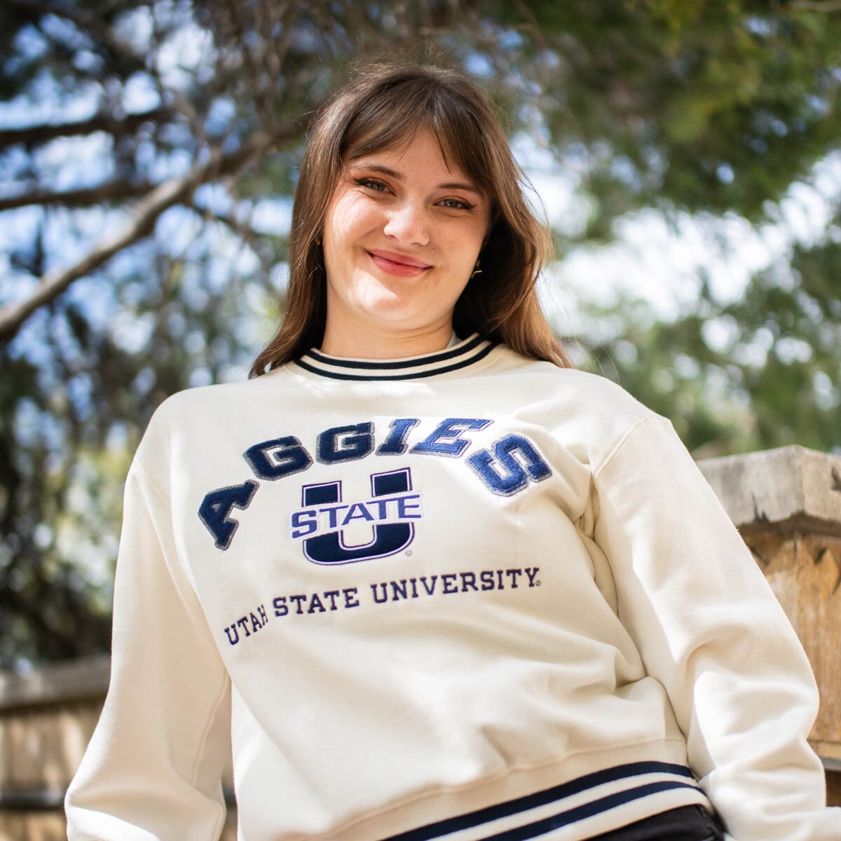 Young woman wearing Aggies u-state applique cream crew sweatshirt with navy trim